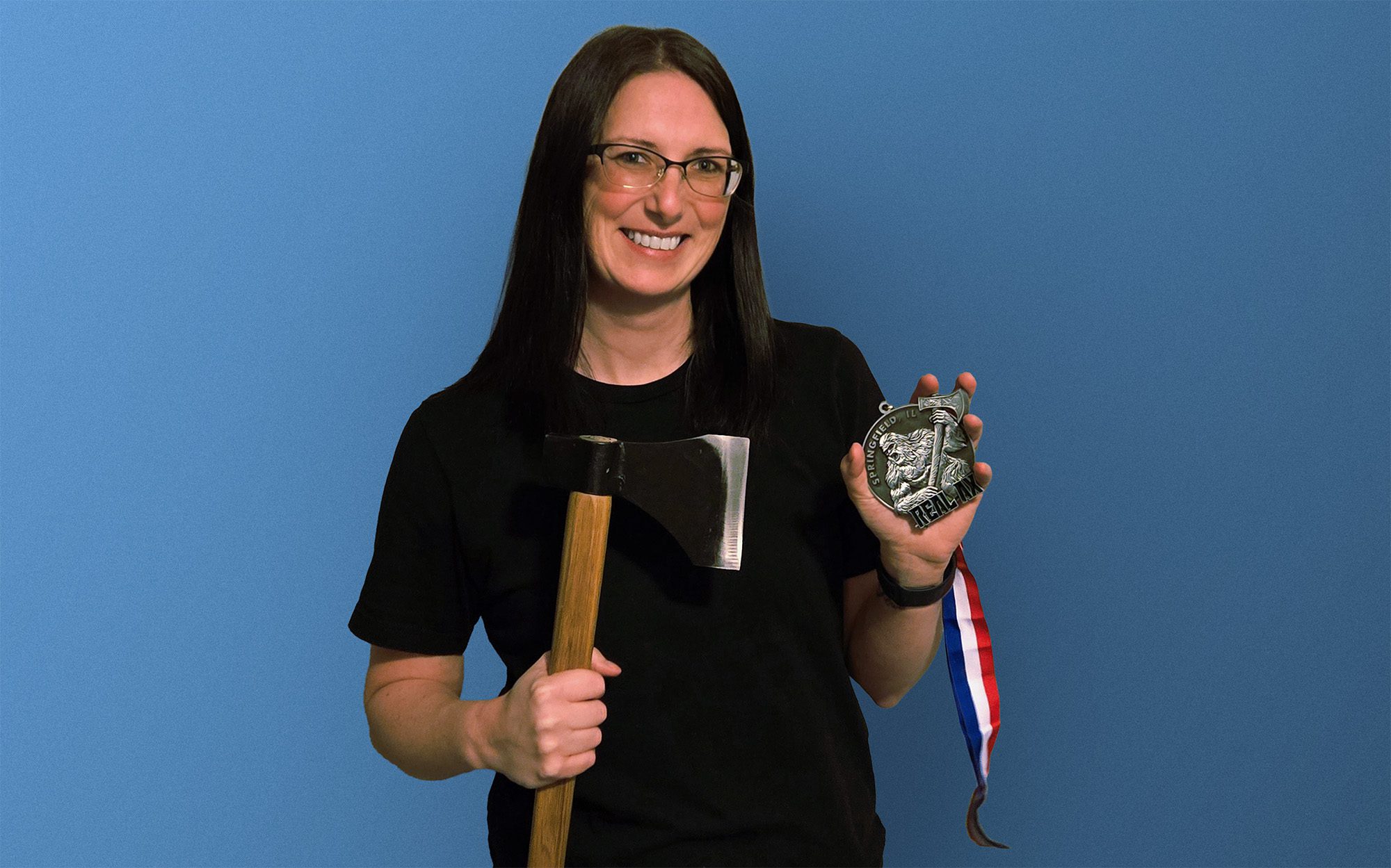 Samantha Brownback holding an axe and an award medal